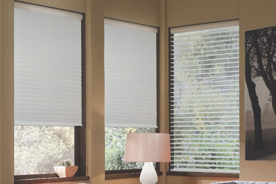 Opaque motorized window shades in Southern California keep hot UV rays out of your home. Gray motorized sheer shades on corner windows next to gray furniture