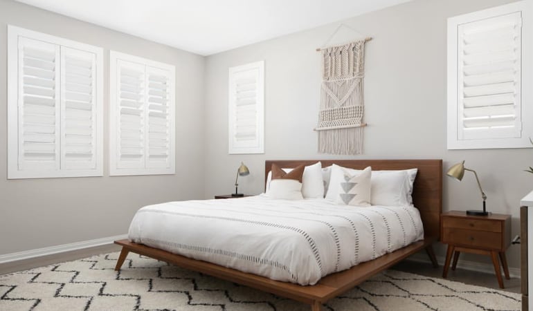 Open shutter louvers will help any Southern California room feel larger. Plantation shutters in a model home bedroom.