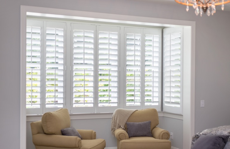 North-South windows can have energy efficiency problems instead of issues with sun glare. White plantation shutters in sitting area
