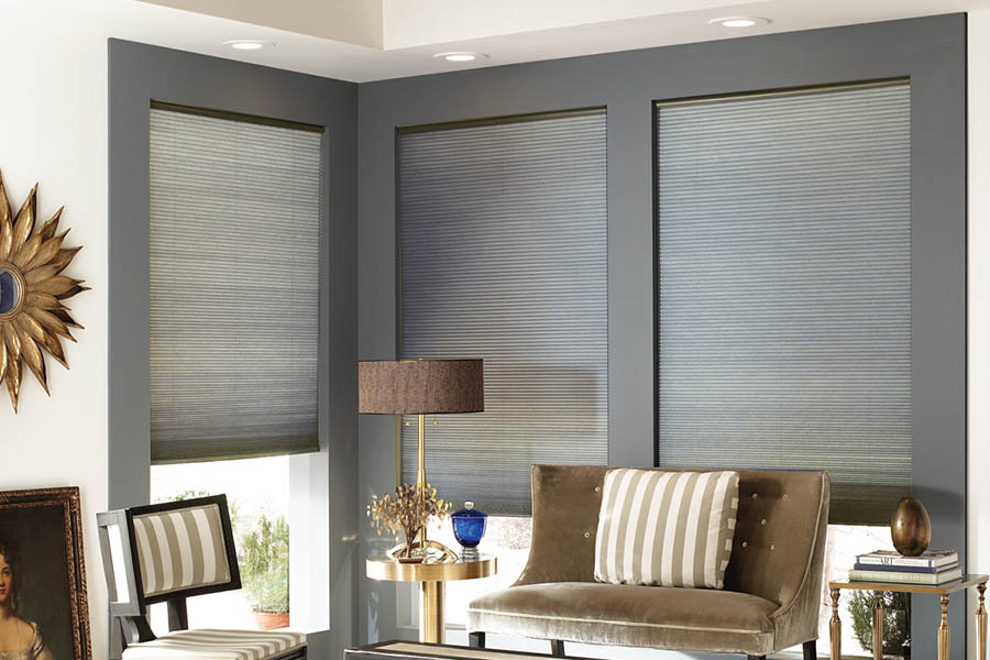 Add style and comfort to your home with cellular shades in Southern California. Gray cellular shades in a corner of a stylish living room.