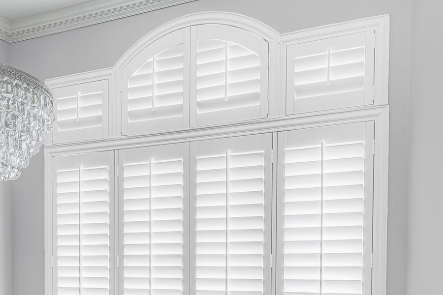 Customize your Palladian windows with white Polywood shutters in Southern California. White Polywood Palladian windows in a dining room.