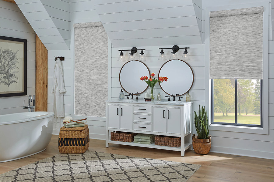 Slim-profile roller shades easily fit shallow windows in your Southern California home. Gray patterned roller shades on bathroom windows